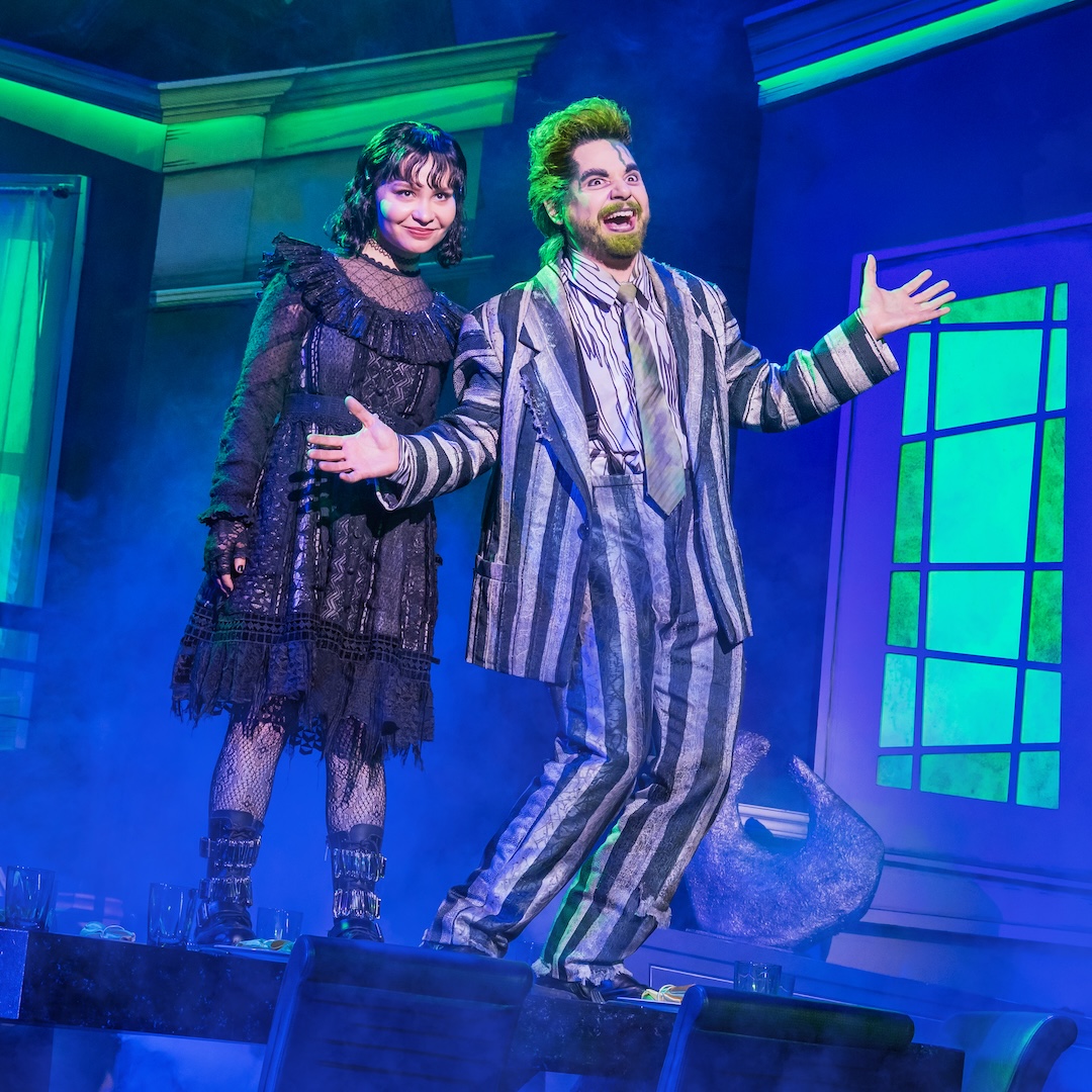 Actors on stage performing in a vivid theatrical production with dramatic lighting and costumes.